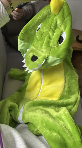 Combinaison dino verte tenue par la capuche, photo d une cliente