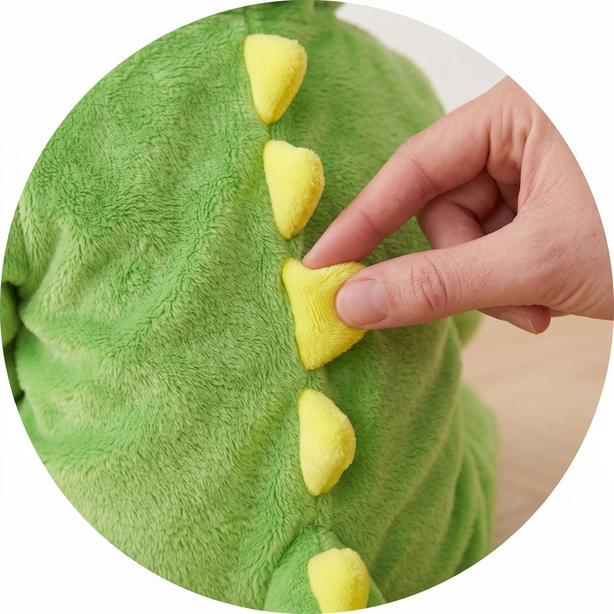 Main qui presse un pic jaune tout doux du costume dinosaure